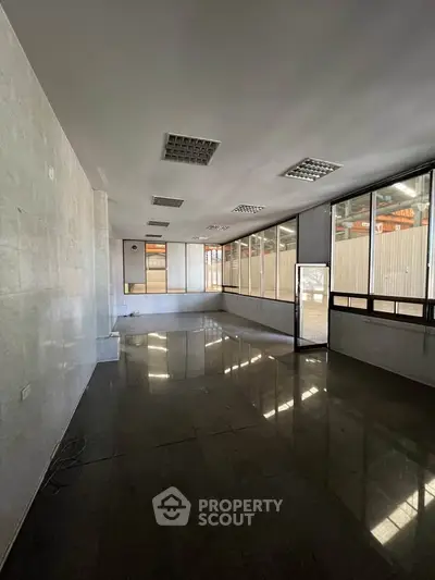 Spacious commercial office space with large windows and tiled flooring, ideal for business setup.