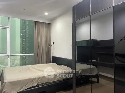 Modern bedroom with large window and sleek furniture in urban apartment