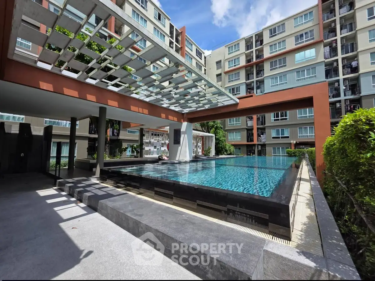 Modern apartment complex with luxurious outdoor pool and stylish architecture.