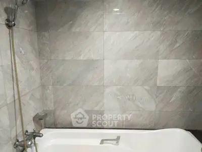 Modern bathroom with elegant marble tiles and sleek bathtub design