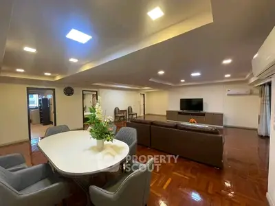 Spacious living room with elegant dining area and modern furnishings, perfect for family gatherings.