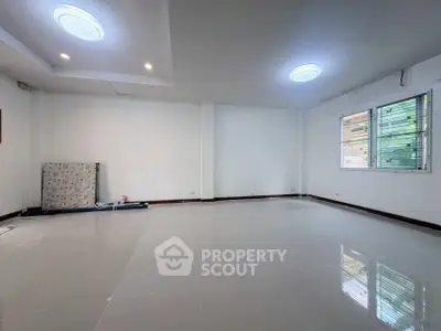 Spacious empty room with glossy tiled floor and large windows, ideal for customization.