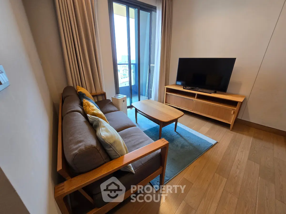 Modern living room with cozy sofa, flat-screen TV, and balcony view in a stylish apartment.