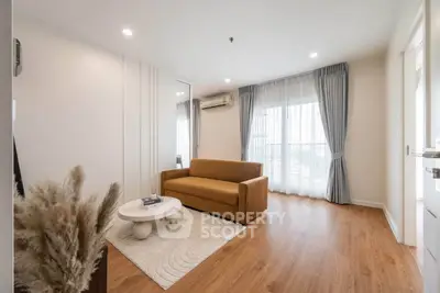 Modern living room with cozy sofa, stylish decor, and large window for natural light.