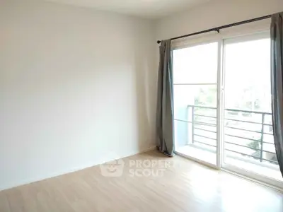 Bright empty room with large window and balcony access, perfect for customization.