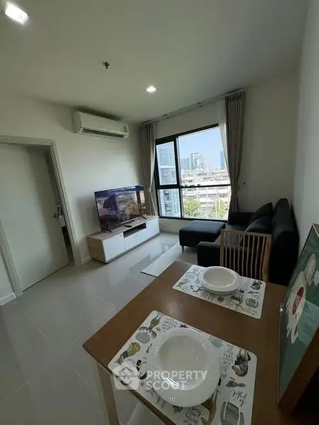 Modern living room with city view, stylish furniture, and dining area in a bright apartment.