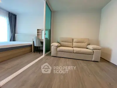 Modern studio apartment with cozy sofa and bed, perfect for urban living.