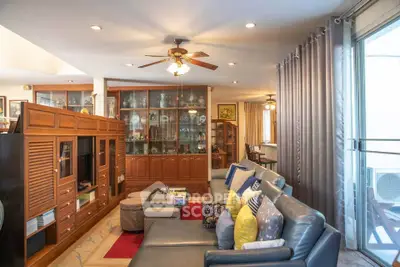 Spacious living room with elegant wooden cabinetry and cozy seating area, perfect for family gatherings.