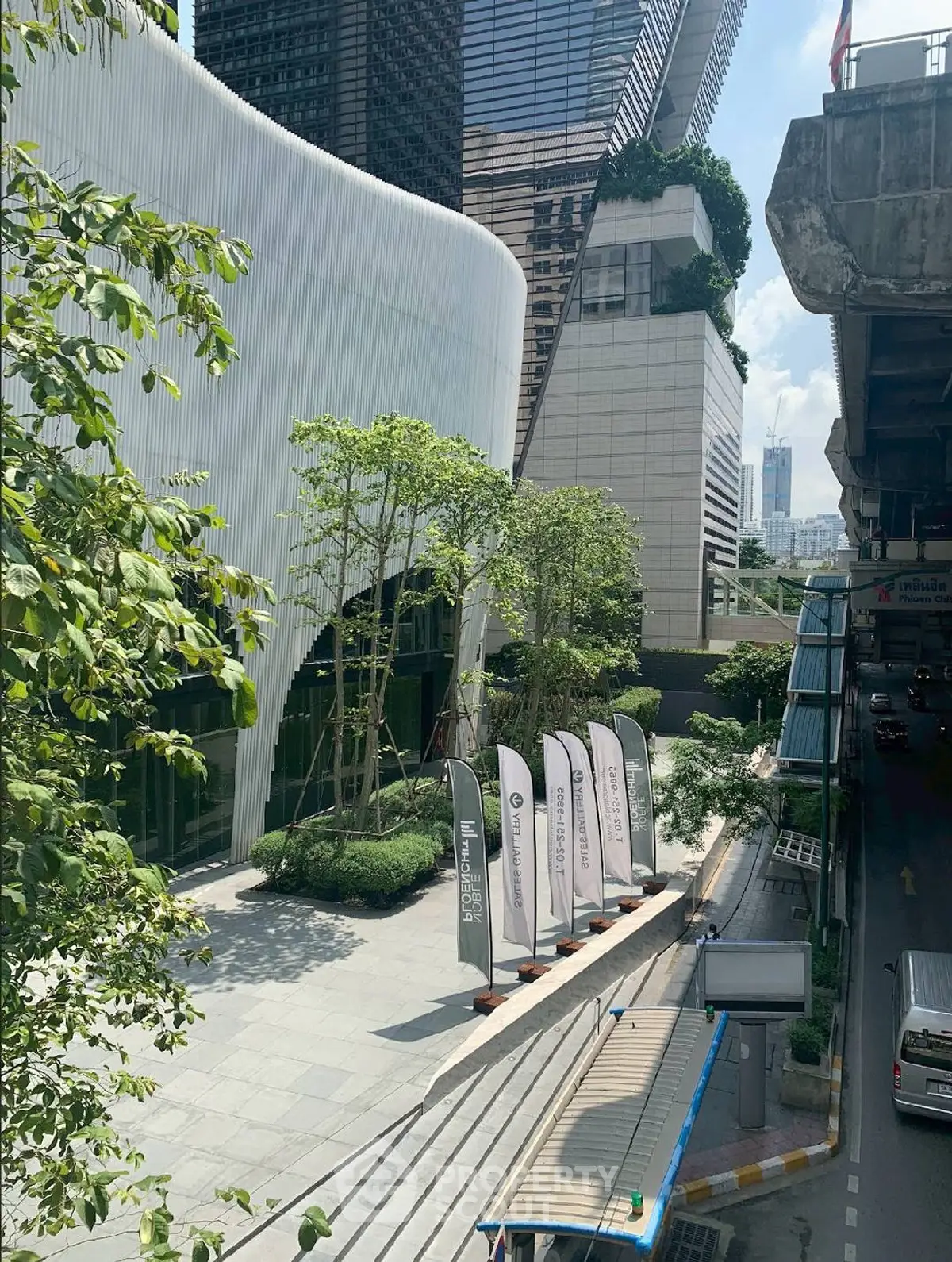 Modern urban building exterior with lush greenery and sleek architectural design.