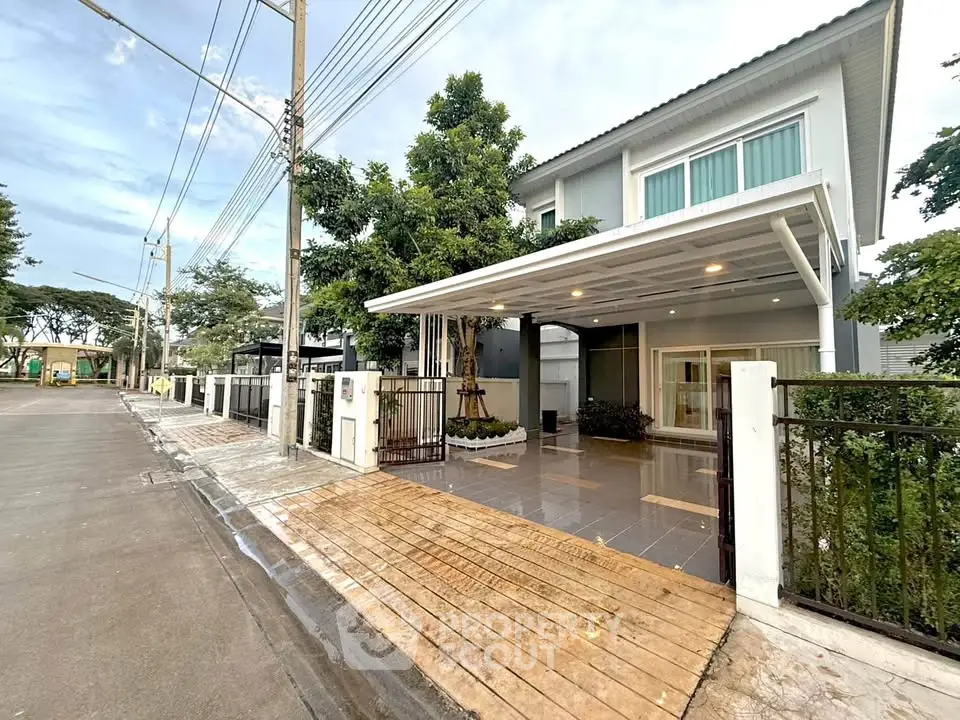 Modern two-story house with spacious driveway and lush greenery in a serene neighborhood.