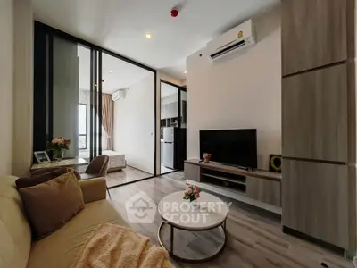Modern living room with stylish decor and air conditioning, featuring a cozy sofa and sleek TV setup.