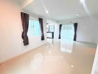 Spacious modern living room with glossy tiled floors and large windows for natural light.