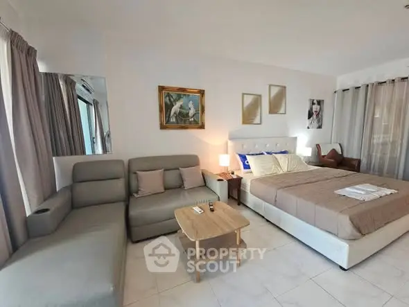 Spacious bedroom with modern decor and cozy seating area