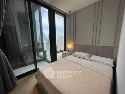 Modern bedroom with large windows offering stunning city views and elegant decor.