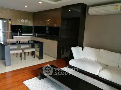 Modern open-layout kitchen and living room with sleek design and hardwood floors.