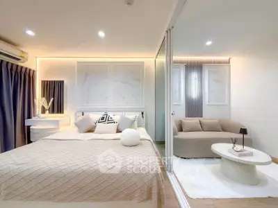 Modern bedroom with elegant decor and cozy seating area, featuring stylish lighting and neutral tones.