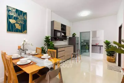 Modern dining area with elegant decor and open kitchen layout in a stylish apartment.