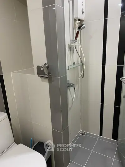 Modern bathroom with sleek tiles and shower area in contemporary apartment.