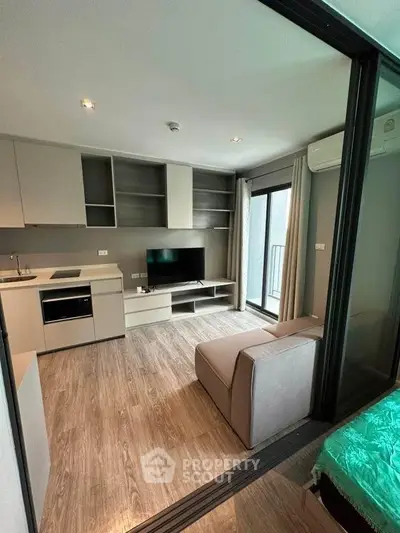 Modern living room with open kitchen and balcony access in stylish apartment