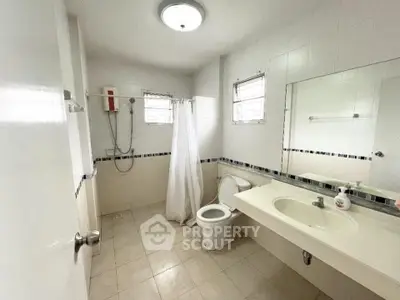Spacious bathroom with modern fixtures and large mirror