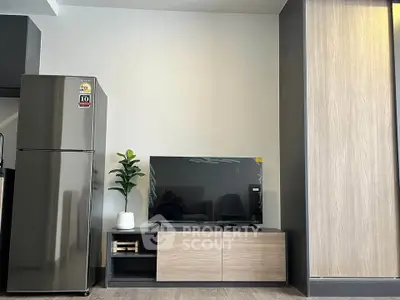Modern living room with sleek TV stand and stainless steel fridge, perfect for contemporary urban living.