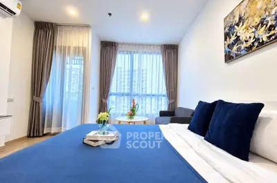 Modern bedroom with blue accents and large windows offering city views