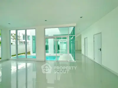 Spacious modern living room with large windows and pool view