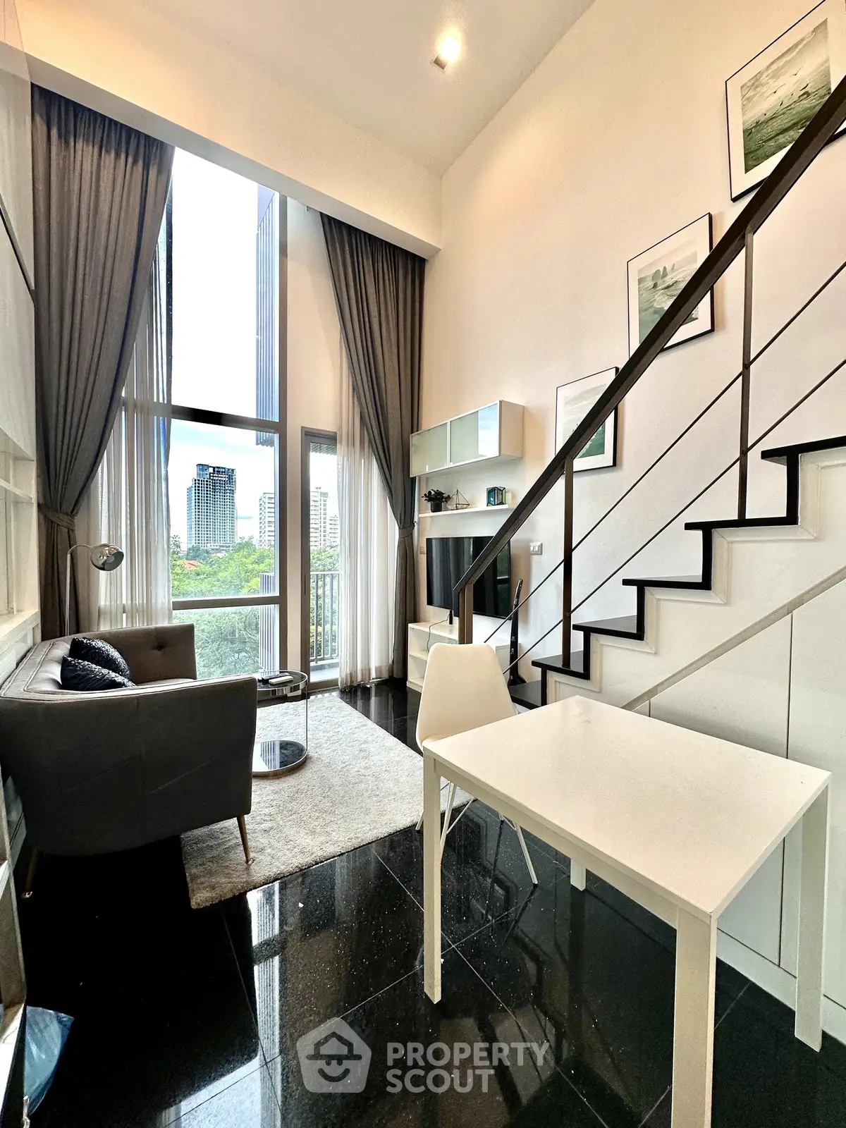 Modern loft apartment with high ceilings and large windows offering city views.