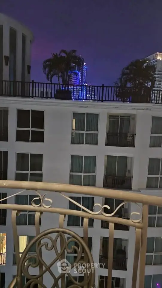 Stunning night view from a balcony overlooking modern high-rise buildings.