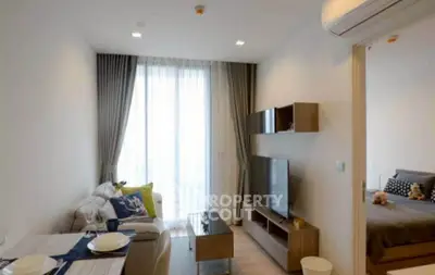 Modern living room with stylish decor and natural light, adjacent to a cozy bedroom.