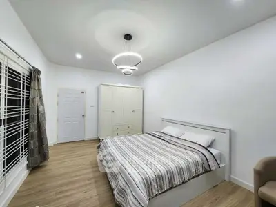 Spacious modern bedroom with elegant lighting and wooden flooring