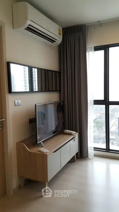 Modern living room with air conditioning and city view, featuring sleek furniture and large windows.