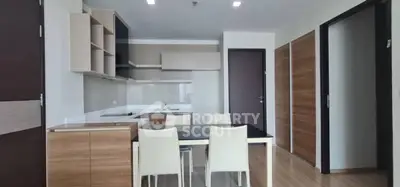 Modern kitchen with sleek cabinetry and dining area in stylish apartment