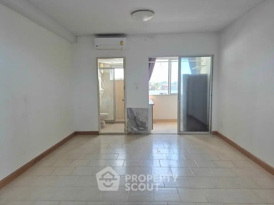 Spacious unfurnished room with tiled flooring and natural light, ideal for customization.