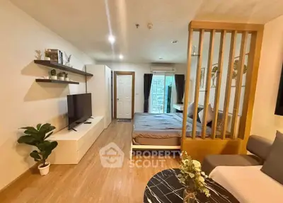 Modern studio apartment with open layout, featuring a cozy living area and stylish bedroom divider.
