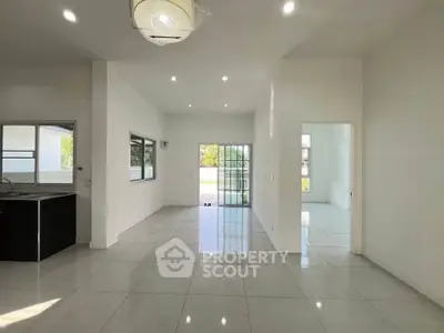 Spacious modern living room with large windows and sleek tile flooring