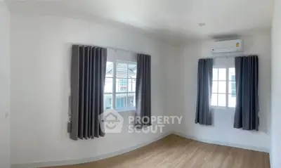 Bright and airy bedroom with large windows and modern air conditioning unit.