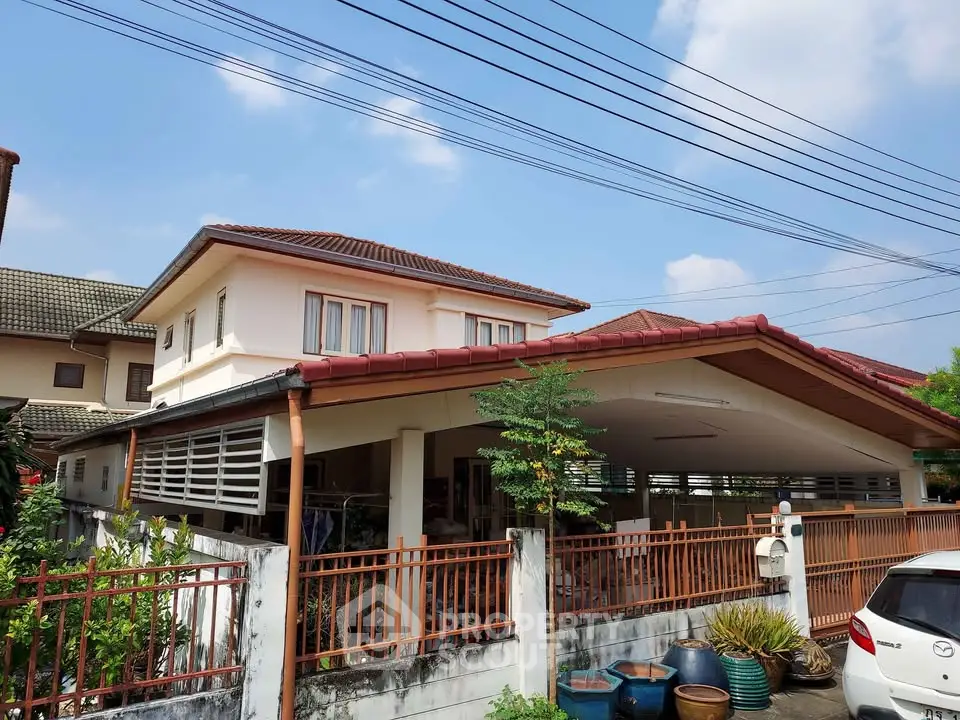 Charming two-story house with carport and lush greenery in a serene neighborhood.