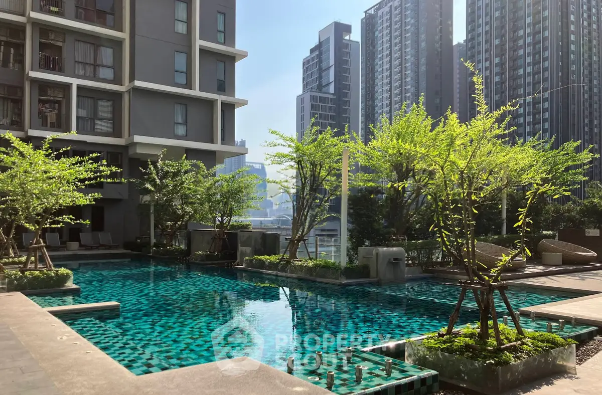 Luxurious urban apartment complex with stunning pool and lush greenery, perfect for city living.