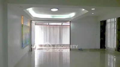Spacious modern living room with glossy floors and large windows for natural light.