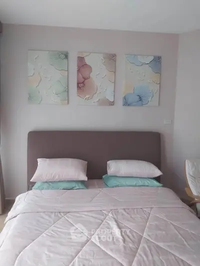 Cozy bedroom with stylish floral artwork and plush bedding