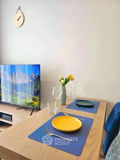 Modern dining area with TV and stylish decor in a cozy apartment setting.