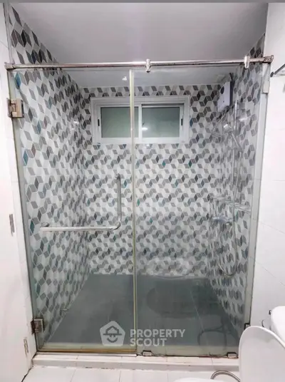 Modern bathroom with stylish geometric tile shower and glass doors