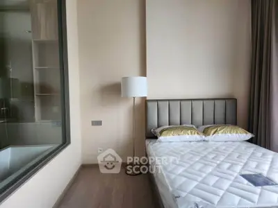 Modern bedroom with elegant decor and large window overlooking bathroom