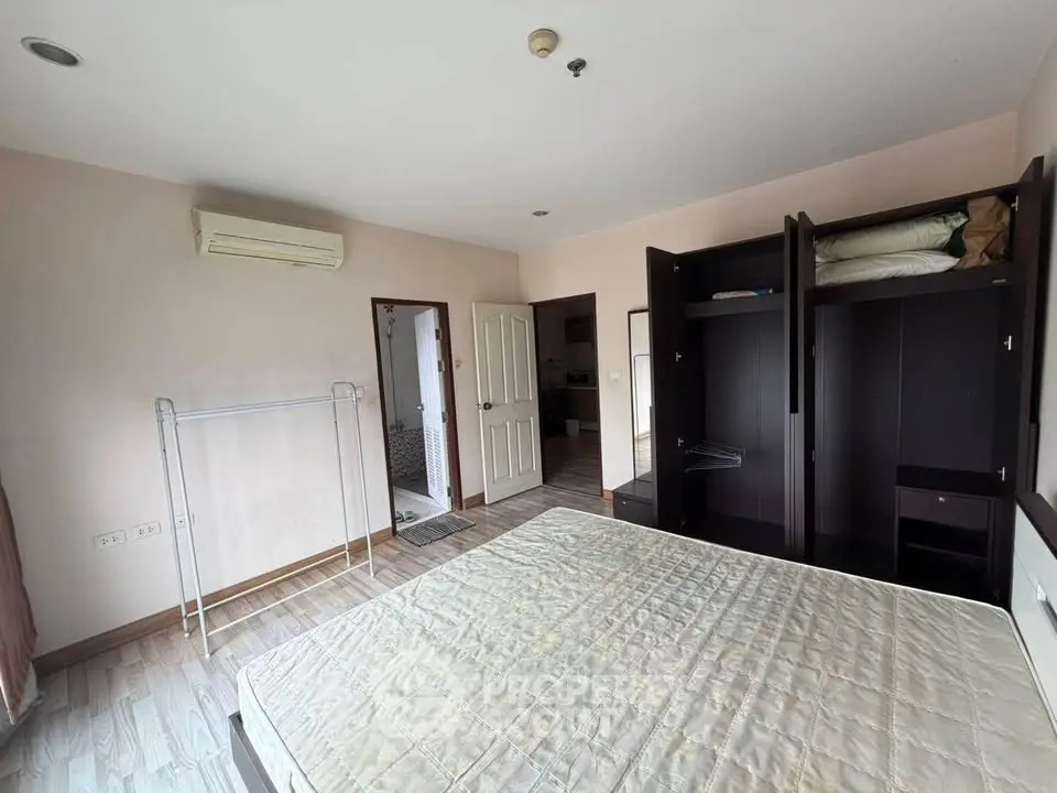 Spacious bedroom with built-in wardrobe and air conditioning in modern apartment.