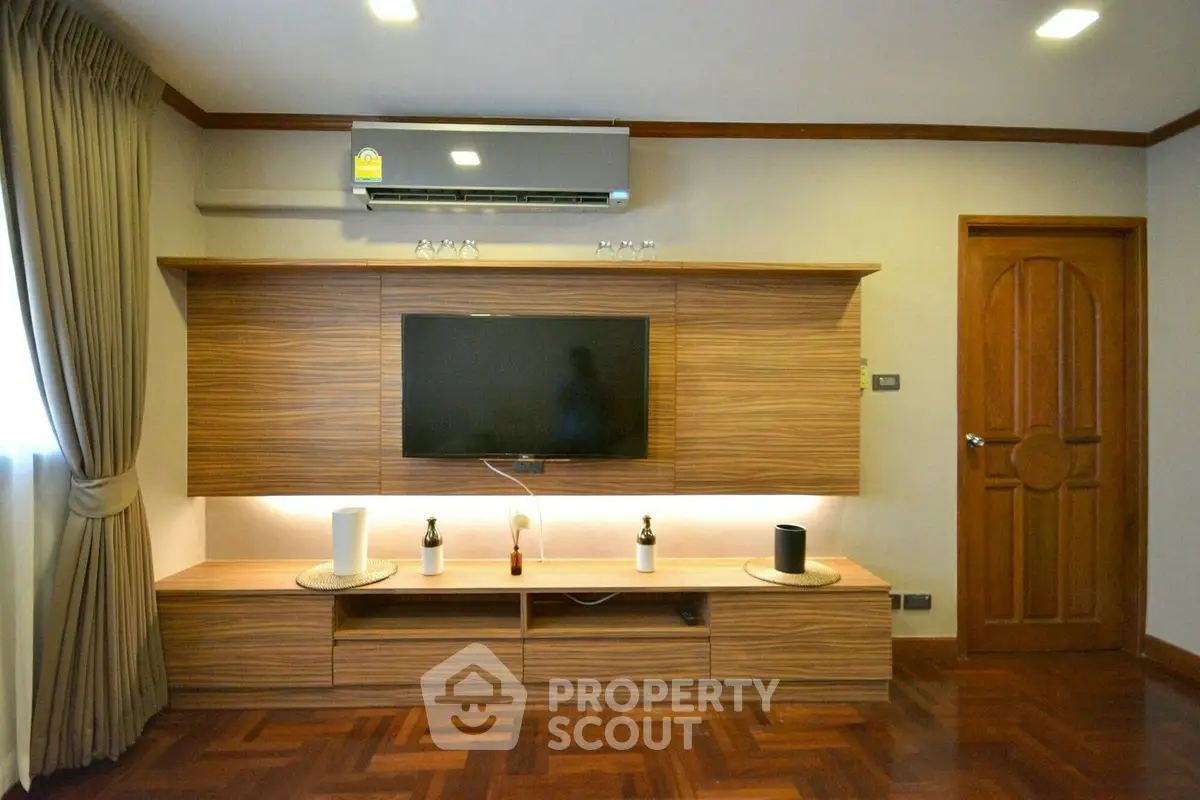 Elegant living room with modern wooden TV unit and parquet flooring