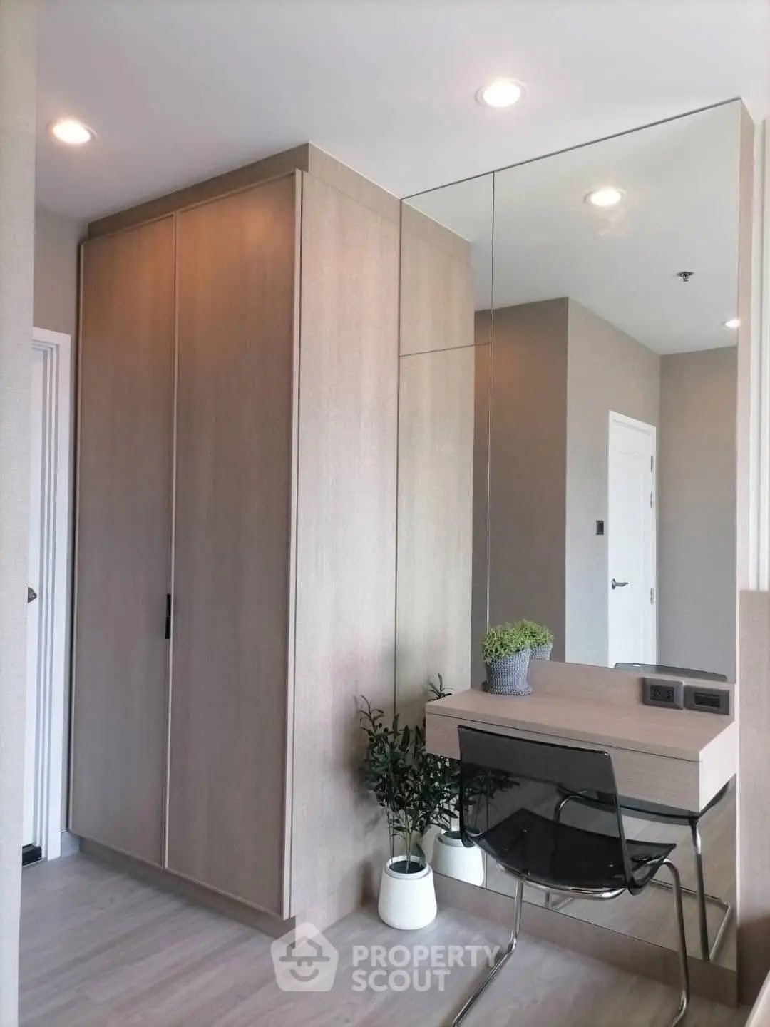 Modern study area with sleek desk, mirror, and built-in wardrobe in stylish apartment.