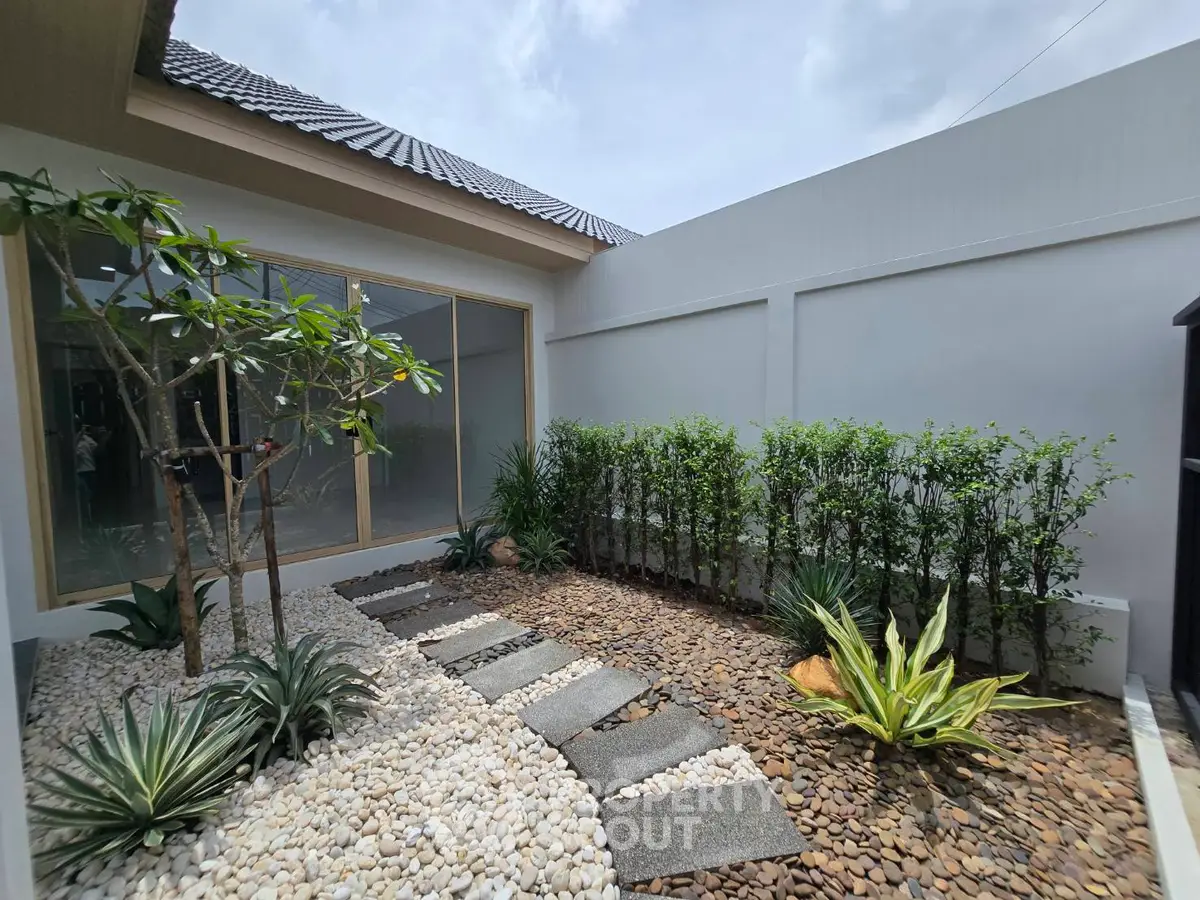 Charming courtyard garden with lush greenery and modern landscaping in a serene residential setting.