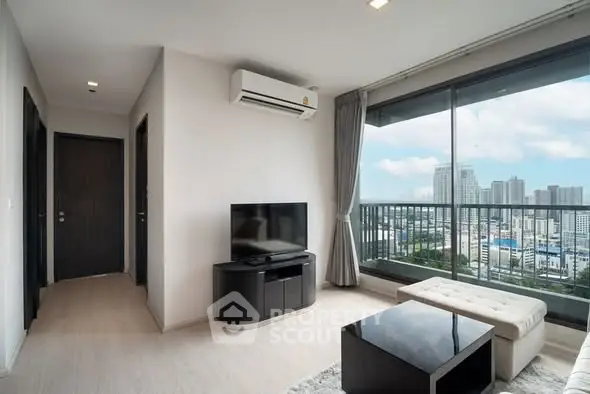 Modern living room with city view, featuring sleek furniture and large windows for natural light.