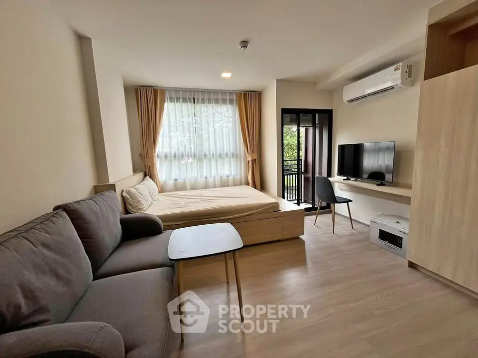 Modern studio apartment with cozy living area and balcony view